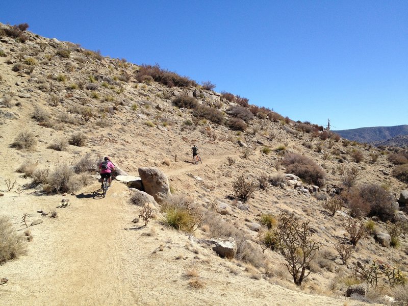 Riders crossing the stone bridge on the back side of the first mound.