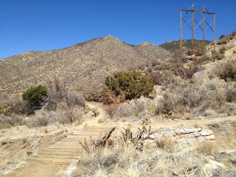 Narrow trail and wooden bridges over arroyos