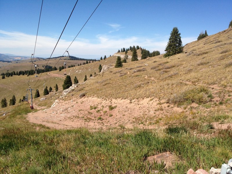 When you reach the top of the Poma lift, do NOT go down the road.  Look for a singletrack that proceeds at a level altitude straight across.