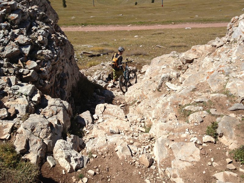 You'll be riding on the summit ridge (or just below it, if you're heading east), and you need to find this notch in the cliff where you can go up/down to continue your ride.