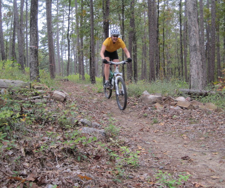 My wife catching a wee bit of air, and grinning on one of the many small drops on this roller coaster of a trail.