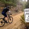 This terribly misleading sign means you're in the right place.  This road is absolutely open to public hiking and biking.  Rural Boulder County roads are full of these misleading signs that should be taken down.  The land around the road is public, you have every right to be on the road!