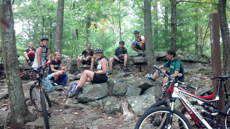 NMBA members taking a break on the natural rock benches after a hot humid climb on Deer Tick before continuing on to Beautiful trail