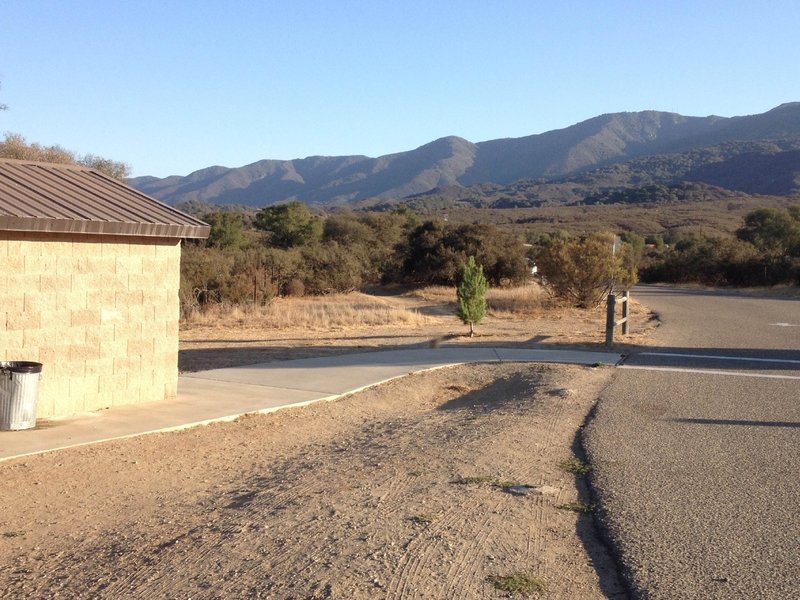 Head straight past the small pine tree to find the start of the trail.  The bathrooms are the stone building to the left.