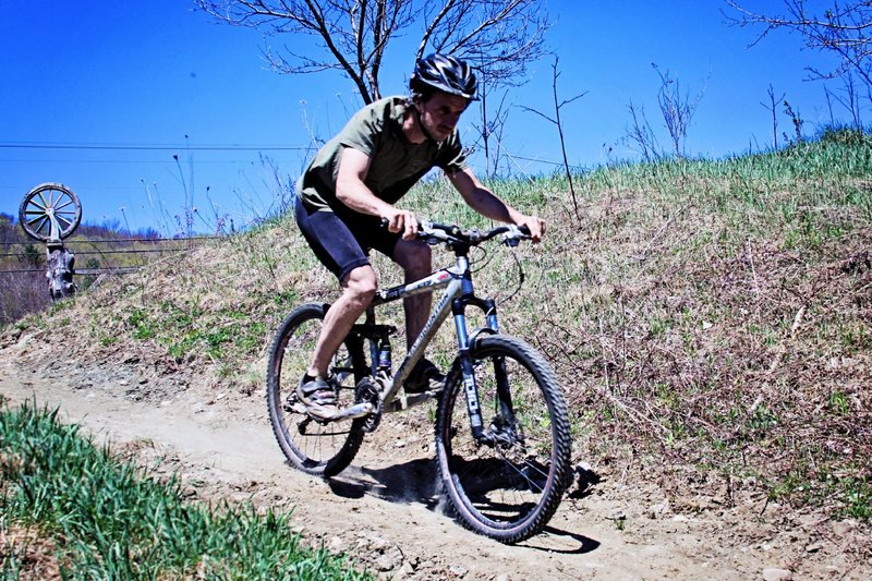 Dropping into Barn Dance from the trailhead. Bike wheel sign totem pokes up over the hill.