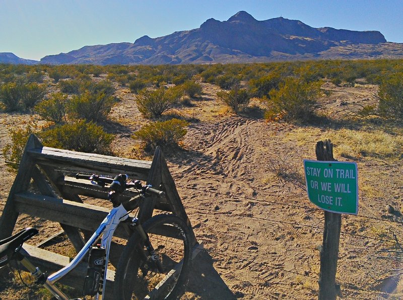 Fence stile and reminder that trail access is provided by a generous landowner