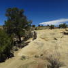 Lesley rides a slickrock ramp while Dave takes in the view.