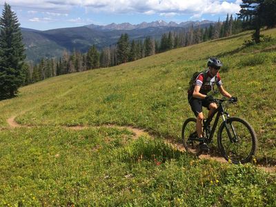 Cruising up Mid Vail Escape with the Gore Range in the distance.