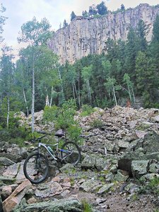 Cliff bands supply the rocks. Bike is just off the trail, which is in the foreground.