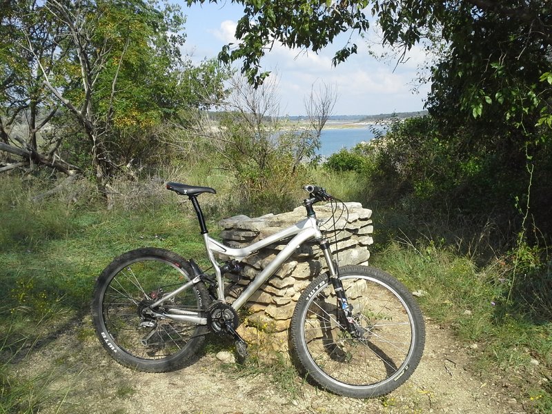 An old hiking trail marker with a scenic view of Lake Georgetown