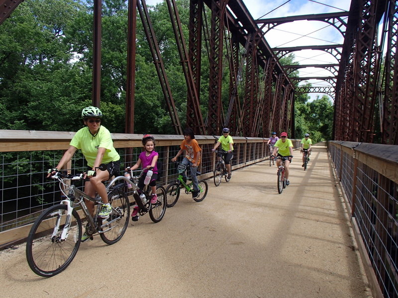 Bicyclists on the historic railroad bridge over Elm Creek on the Southwind Rail Trail.