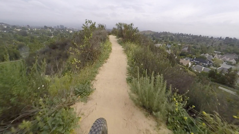 Lower section of Serrania Ridge Trail.  Dog park on your left and homes on your right.  This is a fast clean section of the trail with a baby technical section that you're about to ride over.   Watch for hikers and dogs!