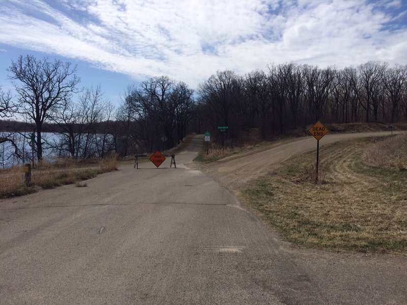 Singletrack start.  Start down the paved path.  Beginning is just past the road sign.