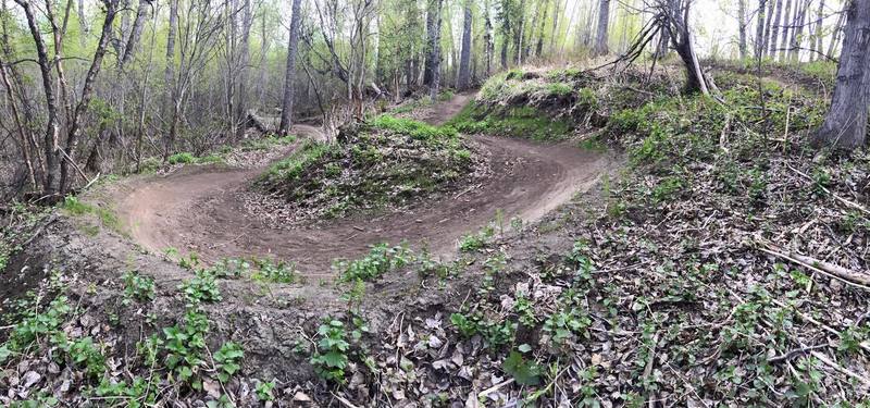 Early Spring view of the big 180 berm at Palmer Bike Park Flow Trail