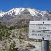 Trail sign for Loowit, Abraham, and Windy ridge with Mt. St. Helens in the background.