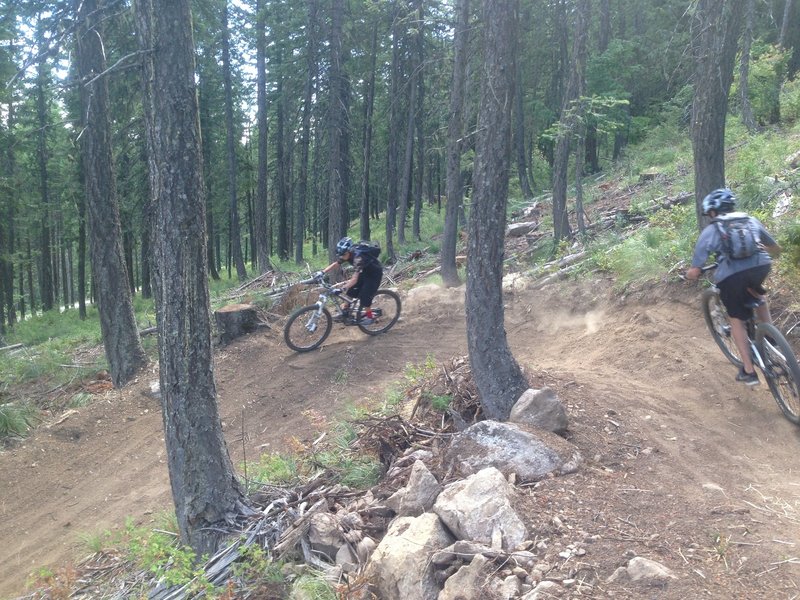 Couple of youngsters flying through the bermed corners inf the new upper section of the trail