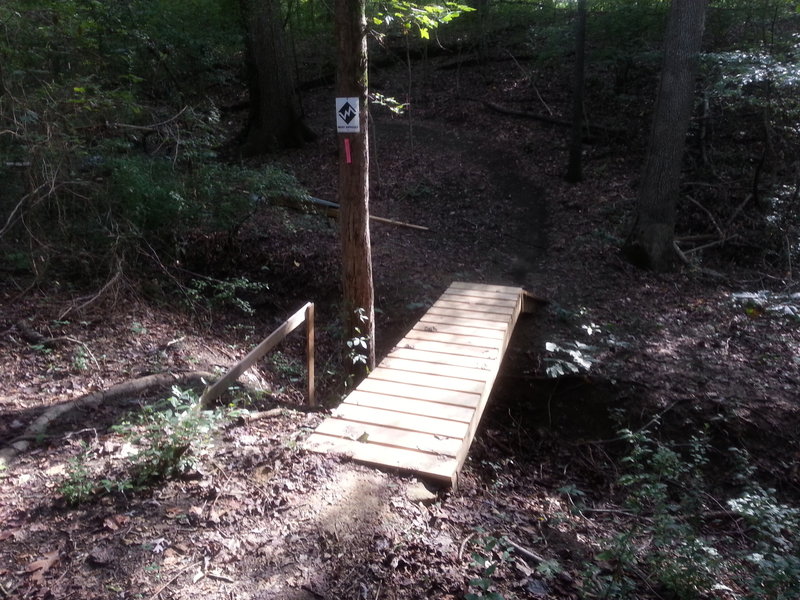 Wooden kicker bridge over a small ravine.