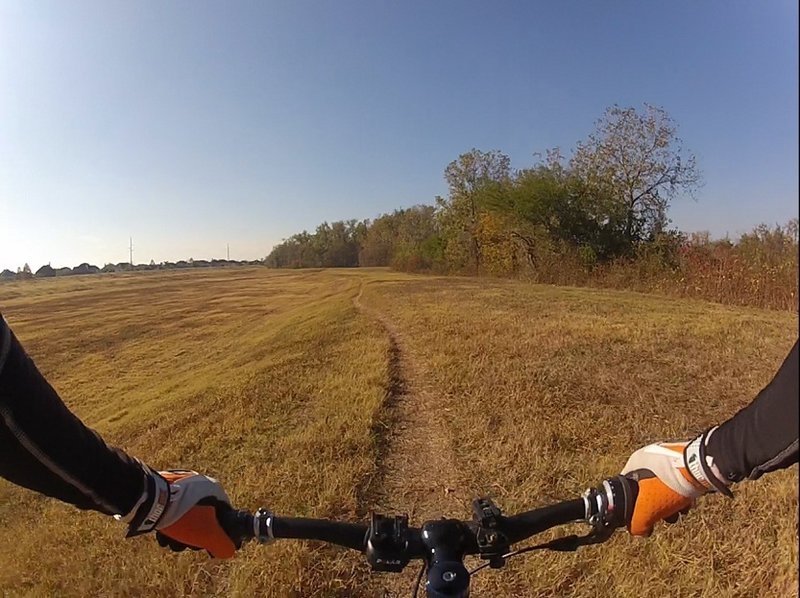 Once exiting the first singletrack section, head through the field to the trees straight ahead to the entrance to the West Loop.