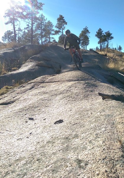 Short descent on a rock outcropping on the Homestead Trail. Watch out for loose sand at the bottom.