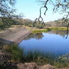 The view of Lake Ilsanjo dam from the Spring Creek Trail. The name "Ilsanjo" is an eponymous contraction of former landowners "Ilsa and Joe" Coney.