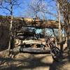 An old smashed, shot-up car right on the trail.