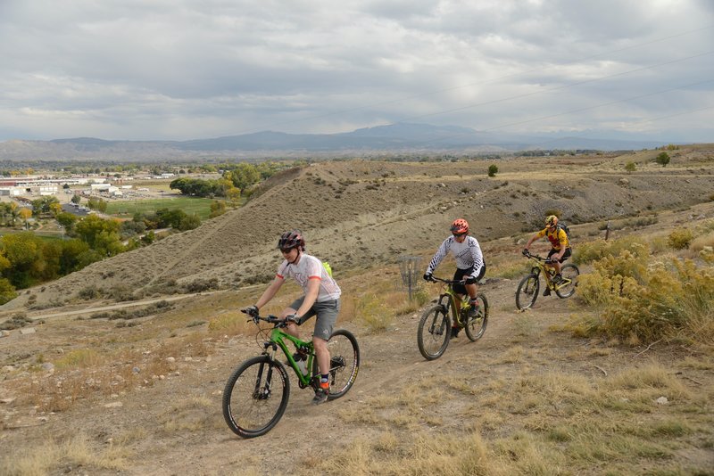 Riders enjoying the singletrack on top of Sunset Mesa, looking south towards the San Juan Mountains.