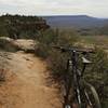 Facing south-southwest on the edge of a cliff. If you have vertigo or could be afraid of heights try a different route on this trail as this area skirts the edge. This part alternates from dirt, to gravel, to slick rock trail.