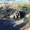 Right turn at the bottom of a hill between two boulders under the paloverde tree.