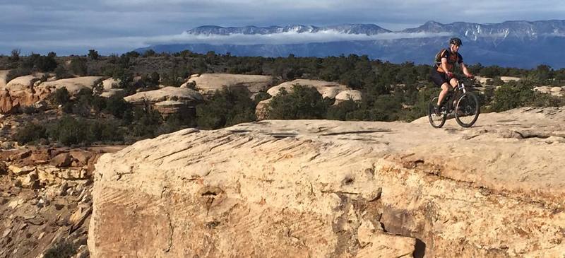 Cliff in front and mountains in the back along the South Rim Trail.