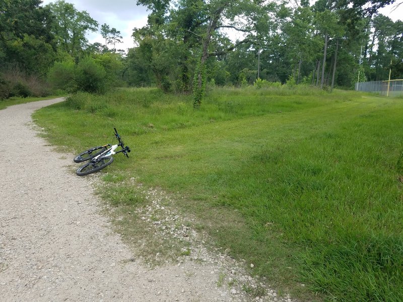 Unmarked entrance to the Red Trail. Take the mowed grass along the baseball diamond. Crushed stone trail is the Purple Trail