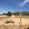 This marker shows the entrance to climbing to WTX.  Climb the jeep road that lies just beyond my bike.