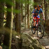 A brightly colored rider navigates a short rock ramp on the Raptor Ridge Trail.