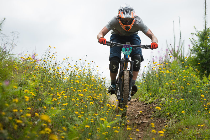 Eric Dukes flies past spring blooms on Thrillium during the Cascadia Dirt Cup.