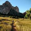 Young legs pedal along scenic singletrack shadowed by prehistoric precipices.