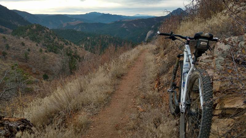 Pikes Peak in the background; the trail snakes down the valley.