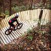 Julia flying into a new berm on Alpha Trail.