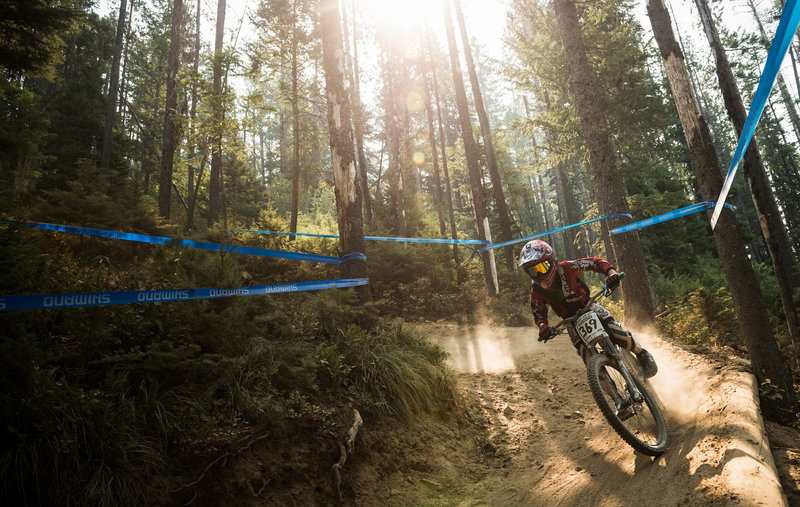 A young racer rounds a dusty turn on Jackass during the NW Cup, Silver Mountain Bike Park.