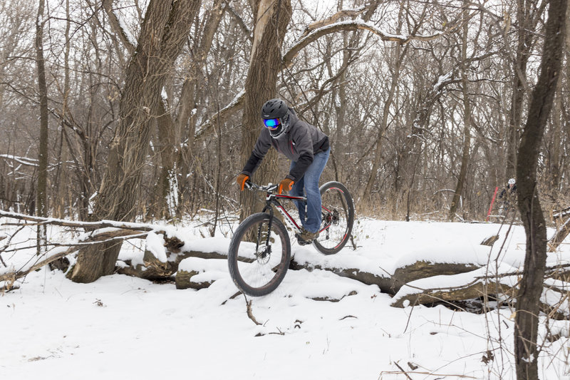 Cody rides down a log roll in a snowy M.B. Johnson Park.