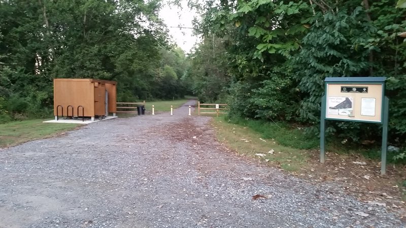 This is the trailhead from the parking lot. A Port-a-John and changing area are located to the left.