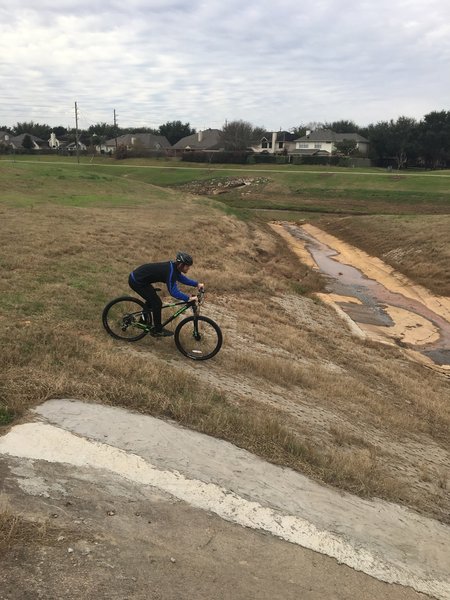 A rider hits a quick downhill through one of the drainages.