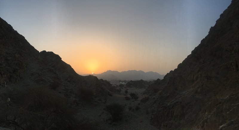 The sun rises over craggy hills in Oman.