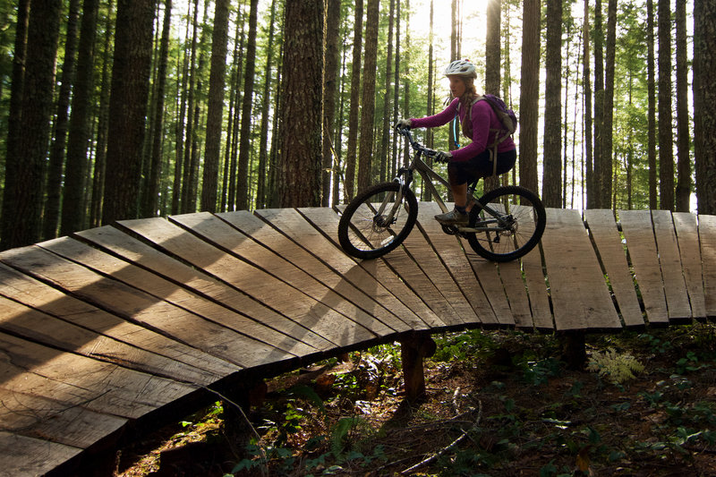 Ashley rides the end of the large coaster on Bonzai Downhill on a perfect fall afternoon at Black Rock Mountain Bike Area.