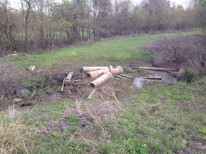 A debris pile offers passage over the wet ditch bottom at the junction of A Trail and D Trail.