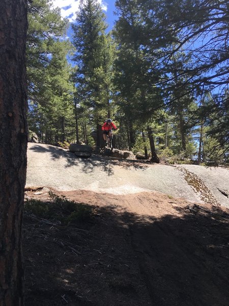 Sending a fun rock feature on the Little Scraggy Trail.