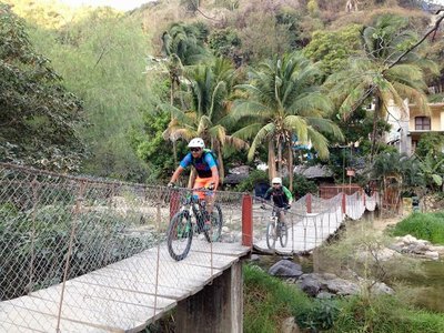 A good-sized suspension bridge over the river near the edge of town.
