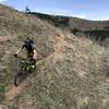 Descending Bonn Scott on narrow singletrack with expansive views of Left Hand Canyon.