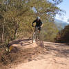 Chaz rides over a large road-side boulder.