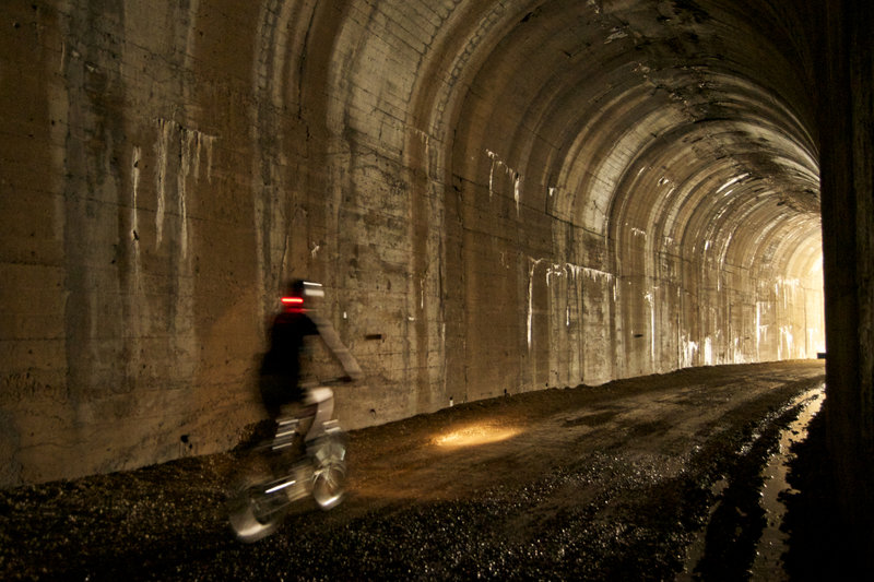 A rider pedals through one of the shorter tunnels on the Trail of the Hiawatha.