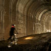 A rider pedals through one of the shorter tunnels on the Trail of the Hiawatha.