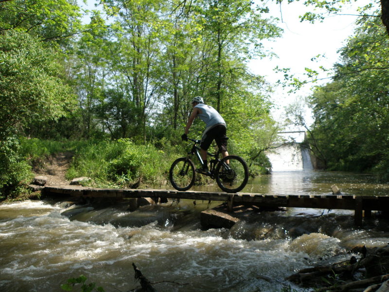 Riding the narrow spillway bridge across Spring Creek.